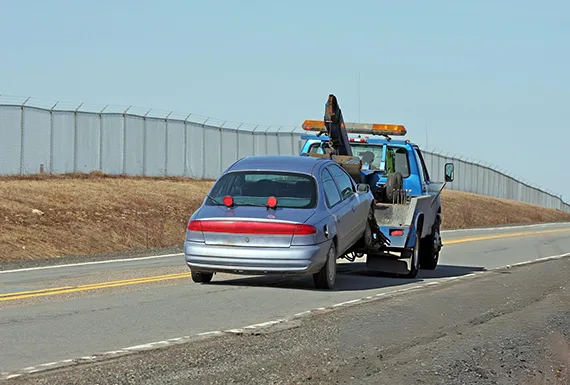 A tow truck in Alpharetta, GA, pulling a car, highlighting we buy junk cars for cash. service