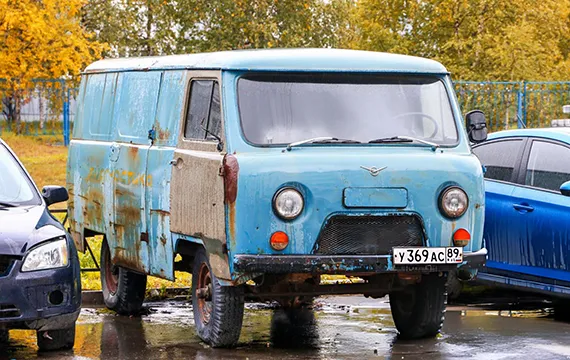 Old blue junk van parked in a lot, promoting Cash for Junk Vans.