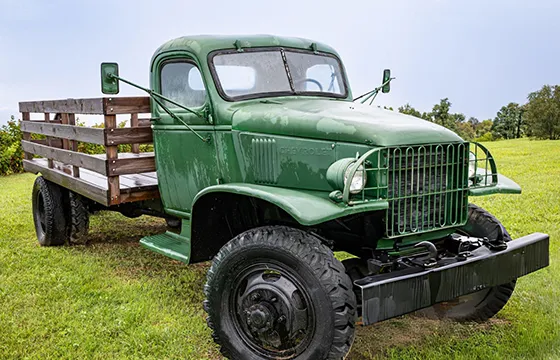 An old green truck parked in a field, representing opportunities for Cash for Junk Trucks in Buckhead, GA.