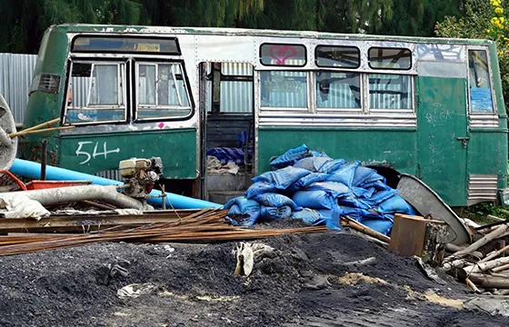 A bus next to a debris pile, representing the service of cash for junk SUVs in Duluth, GA.