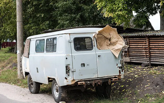 Old van with a tarp in Duluth, GA, highlighting junk car removal services for local residents.