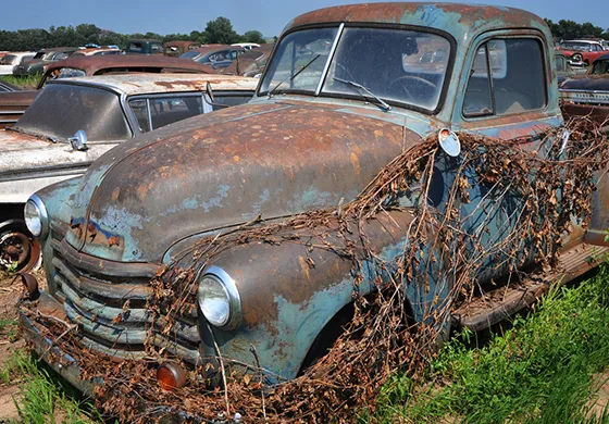 Old rusty car with vines, symbolizing the need to sell your car fast for better options.
