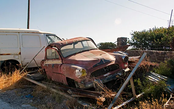 An old car rests atop a heap of junk in a scene related to buying junk cars for cash in Lawrenceville GA.