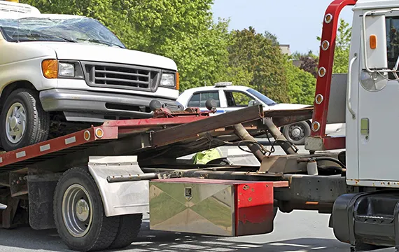 A tow truck transporting a car on its flatbed for reliable junk car removal services.
