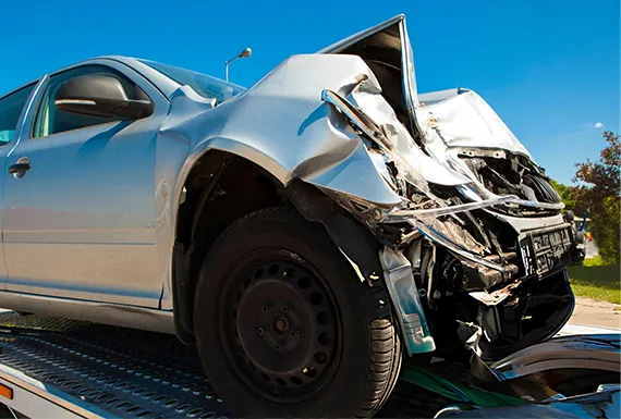 A tow truck is towing a car on a street in Snellville GA for junk vehicle removal services.