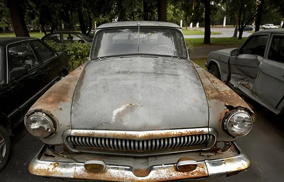 Old rusty car parked on the street, emphasizing the need for junk car removal services in Stone Mountain, GA.