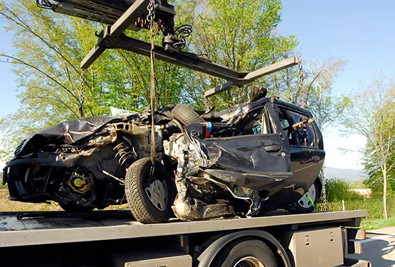 A flatbed truck transporting a car, showcasing efficient junk car removal services.