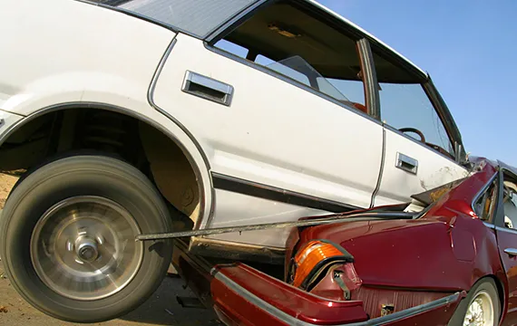 A car being lifted off the ground by another vehicle, showcasing the junk SUV removal service in Stone Mountain, GA.