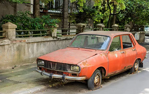 An old rusty car parked on the roadside for cash for junk trucks in Suwanee GA.